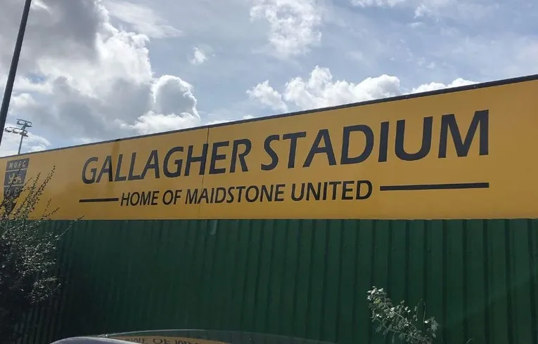 Biển hiệu Gallagher Stadium chào đón du khách đến sân vận động của Maidstone United, với logo nhà tài trợ Gallagher Group