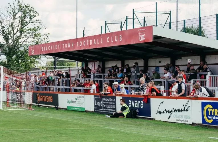 Cảnh quan sân vận động St James Park Brackley trong một ngày diễn ra trận đấu, với khán giả trên khán đài