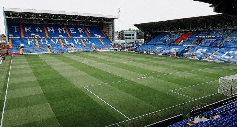 Góc nhìn từ khán đài chính của sân Prenton Park, cho thấy hàng ghế cổ kính và tầm nhìn thoáng đãng ra sân cỏ