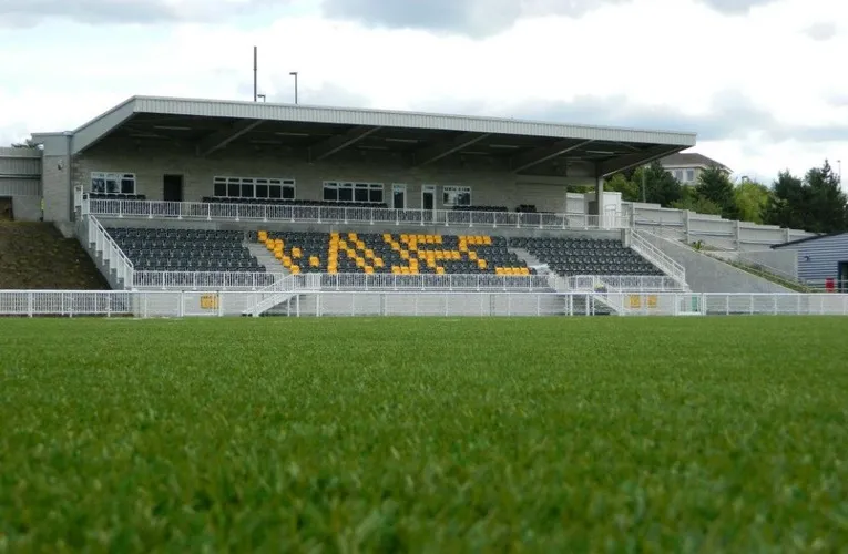 Khán đài chính Main Stand tại Gallagher Stadium, sân nhà của Maidstone United, với các hàng ghế xanh đỏ và mái che hiện đại