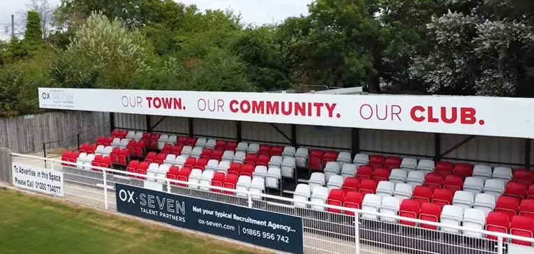 Khu vực khán đài có mái che tại St James Park Brackley, nơi người hâm mộ đứng xem trận đấu
