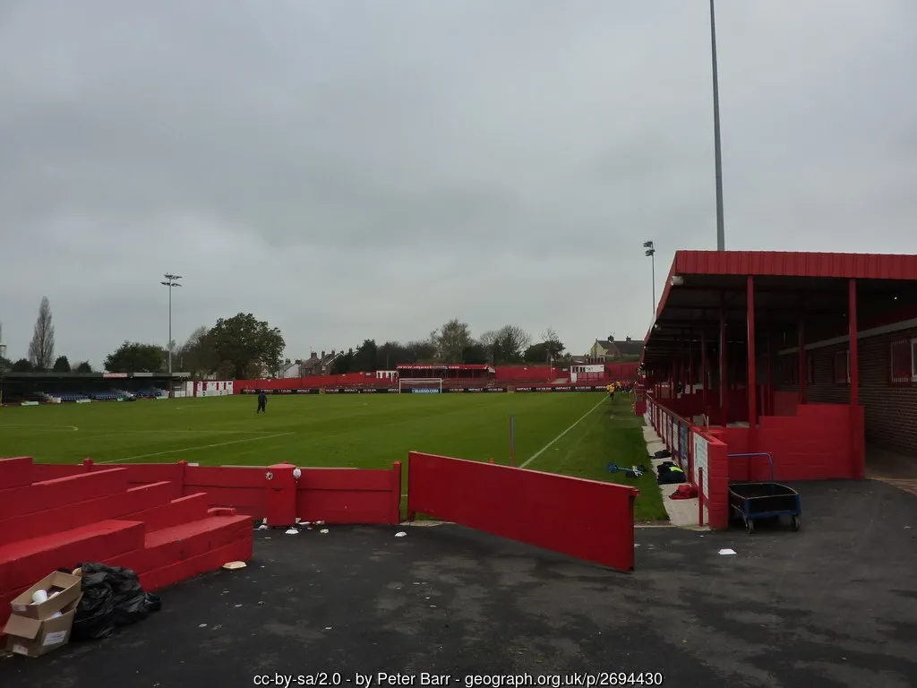Khung cảnh bên trong sân Impact Arena nhìn từ khán đài, tập trung vào đường biên sân cỏ Alfreton Town