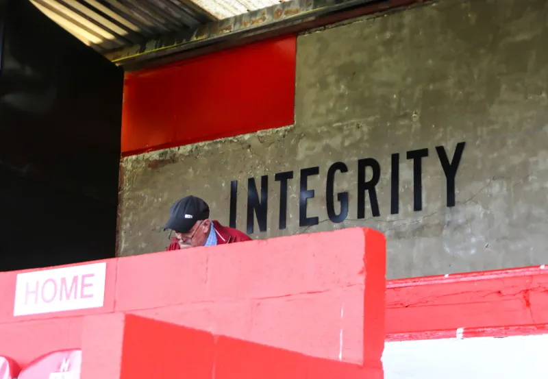 Một cổ động viên Salford City FC đang đeo khăn quàng cổ và biểu ngữ, thể hiện tình yêu với đội bóng