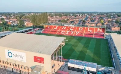 Toàn cảnh sân vận động Sincil Bank nhìn từ trên cao, nổi bật giữa cảnh quan thành phố Lincoln với Nhà thờ Lincoln uy nghi