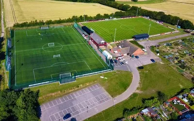 Tổng quan sân vận động Bloomfields, thánh địa của Needham Market FC nhìn từ trên cao, thể hiện kiến trúc đặc trưng của các sân bóng đá hạng thấp ở Anh.