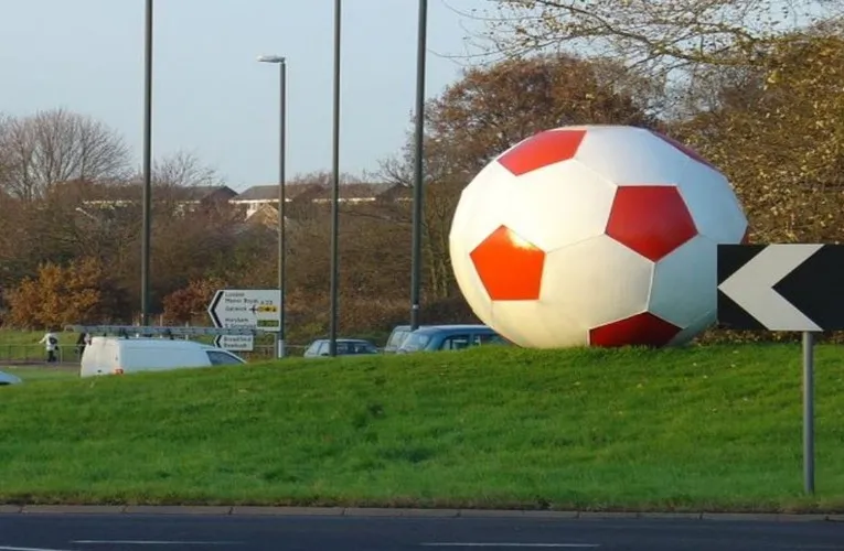 Vòng xoay bên ngoài Broadfield Stadium với tác phẩm điêu khắc bóng đá, biểu tượng địa phương cho CLB Crawley Town.